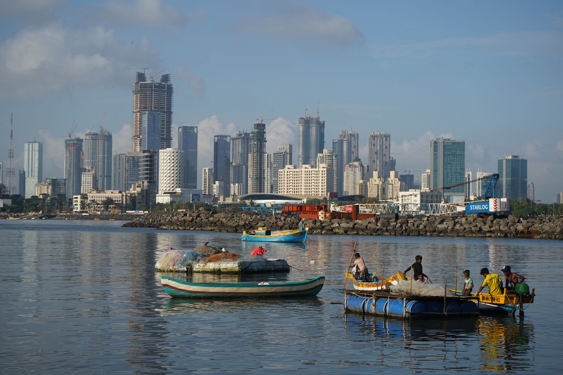 Mumbai skyline seen across the bay with fishing boats